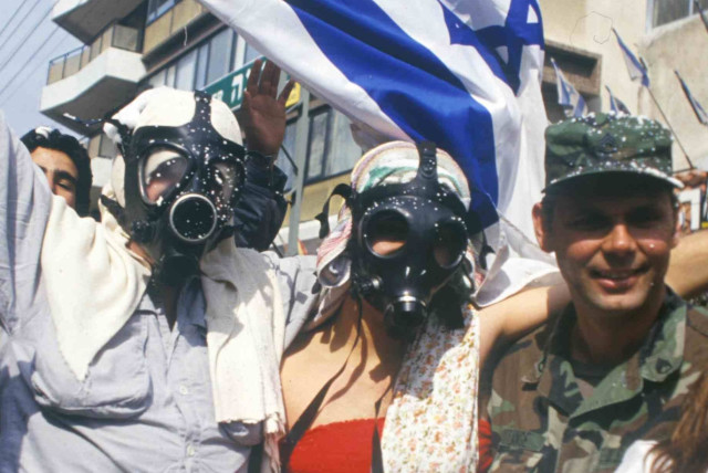 An American soldier joins a Purim celebration on the streets of Israel as the Gulf War ends. February 1991 (credit: Alex Levac, IDF archive)