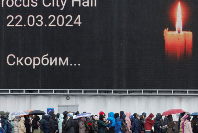   People line up to lay flowers at a makeshift memorial to the victims of a shooting attack set up outside the Crocus City Hall concert venue in the Moscow Region, Russia, March 24, 2024.  (credit: MAXIM SHEMETOV/REUTERS)