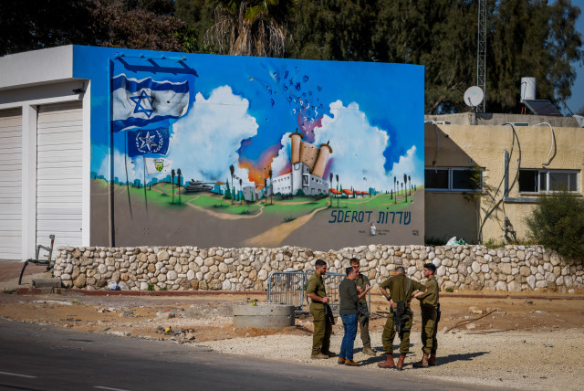  Israeli soldiers standing near a graffiti at the site of the Old Sderot Police Station that was attacked by Hamas terrorists on October 7, 2023, in the southern Israeli city of Sderot, March 11, 2024. (credit: Chaim Goldberg/Flash90)