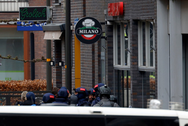 Dutch police officers stand near the Cafe Petticoat, where several people are being held hostage in Ede, Netherlands March 30, 2024.  (credit: PIROSCHKA VAN DE WOUW/REUTERS)