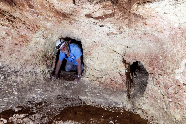  Yinon Shivtiel, a historian at Zefat Academic College crawls through an opening in a cave, part of an immense underground hideout comprising narrow tunnels and large storage spaces that was dug by Jewish villagers nearly 2,000 years ago. (credit: REUTERS/Ari Rabinovitch)