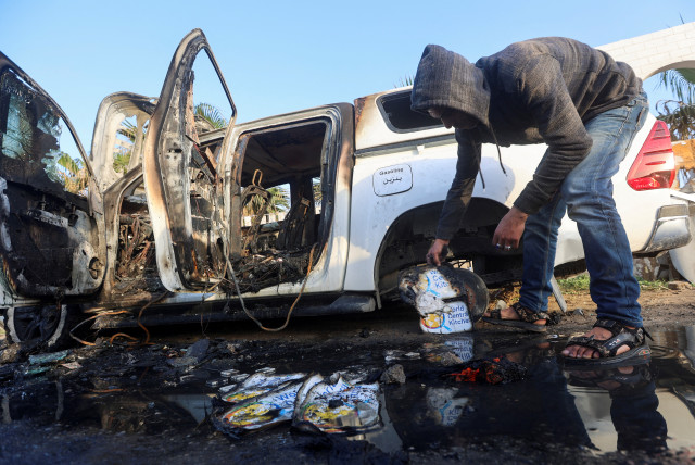  A Palestinian inspects near a vehicle where employees from the World Central Kitchen (WCK), including foreigners, were killed in an Israeli airstrike. April 2, 2024. (credit: REUTERS/AHMED ZAKOT)