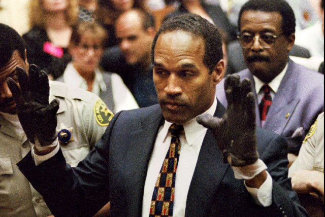  O.J. Simpson, wearing the blood stained gloves found by Los Angeles Police and entered into evidence in Simpson's murder trial, displays his hands to the jury at the request of prosecutor Christopher Darden in this file photograph from June 15, 1995 as his attorney Johnnie Cochran, Jr. (R.) looks o (credit: VIA REUTERS)