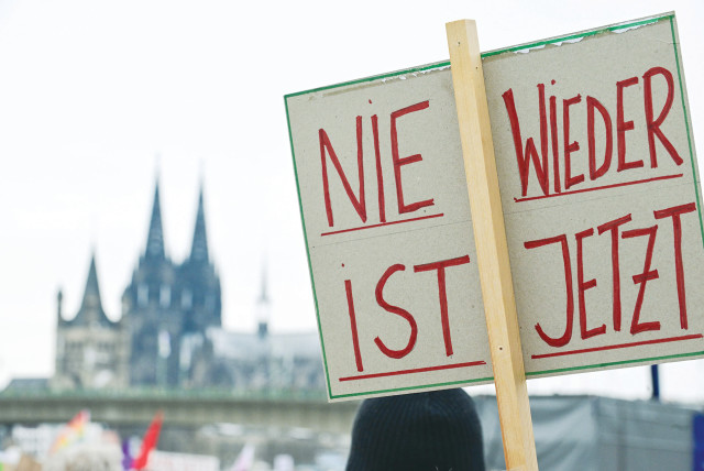  A DEMONSTRATOR holds a sign that reads “Never Again is Now” during a protest against right-wing extremism and the far-Right opposition Alternative for Germany (AfD), in Cologne, in January.  (credit: Jana Rodenbusch/Reuters)