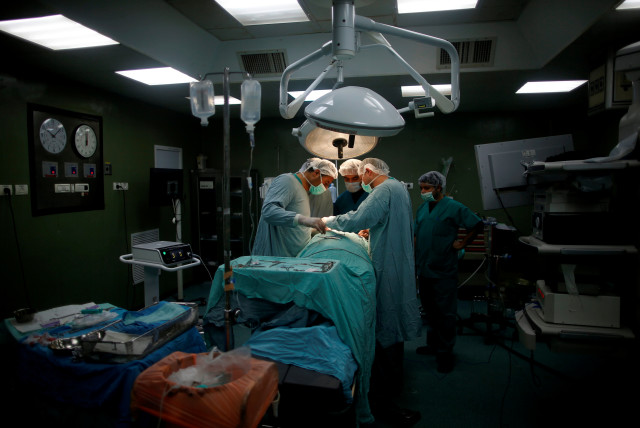  Doctors and medics perform a surgery for Palestinian woman Sadeya al-Shafi, 60, in the operating room at Shifa hospital, Gaza's largest public medical facility, in Gaza City, March 29, 2017. (credit: REUTERS)