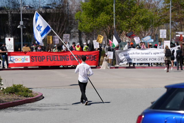  A counter-protester holding an Israeli flag walks into the parking lot near a protest at Google Cloud offices in Sunnyvale, California, U.S. on April 16, 2024. (credit: REUTERS/NATHAN FRANDINO)