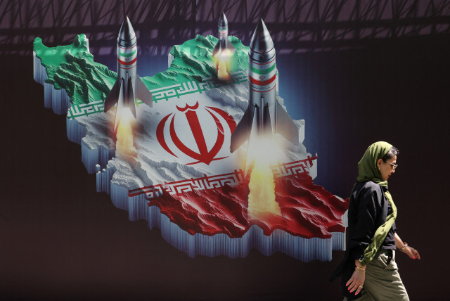  An Iranian woman walks past an anti-Israel banner with a picture of Iranian missiles on a street in Tehran, Iran April 19, 2024. (credit: MAJID ASGARIPOUR/WANA (WEST ASIA NEWS AGENCY) VIA REUTERS)