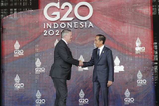  OECD SECRETARY-GENERAL Mathias Cormann (L) shakes hands with Indonesian President Joko Widodo as he arrives for the G20 leaders’ summit in Bali, Nov. 2022. (credit: Mast Irham/Pool/AFP via Getty Images)