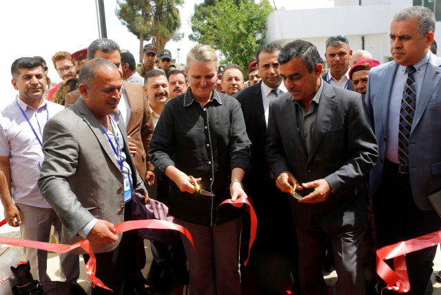  UNDP Resident Representative for Iraq, Lise Grande (C) and Secretary-General of Iraq's Council of Ministers Mahdi al-Alaq (2nd R) cut a ribbon during the inauguration of a water treatment plant on the outskirts of Qaraqosh, Iraq, May 7, 2017. Picture taken May 7, 2017. (credit: REUTERS/DANISH SIDDIQUI)