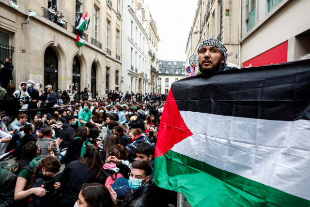  A person holds a Palestinian flag as people take part in the occupation of a street in front of the building of the Sciences Po University in support of Palestinians in Gaza, during the ongoing conflict between Israel and the Palestinian Islamist group Hamas, in Paris, France, April 26, 2024. (credit: REUTERS/GONZALO FUENTES)