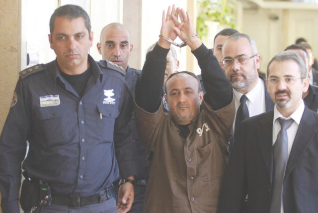   MARWAN BARGHOUTI es escoltado esposado por la policía hasta el Tribunal de Magistrados de Jerusalén en 2012. (credit: FLASH90)