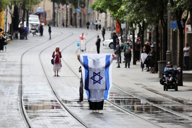 Varias personas permanecen inmóviles durante una sirena de dos minutos que marca el Día de Conmemoración del Holocausto en Jerusalén el 6 de mayo de 2024. (credit: NIR ELIAS/REUTERS)