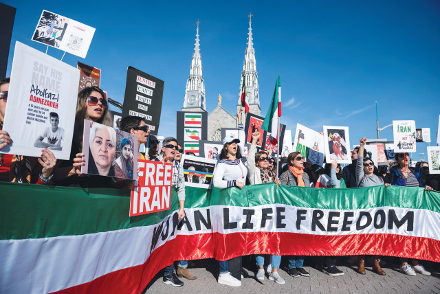  Manifestantes en apoyo a las mujeres de la República Islámica de Irán sostienen una pancarta en la que se lee ‘Mujer Vida Libertad,’ en Ottawa, 2022.  (Fotografía: Spencer Colby/Reuters)