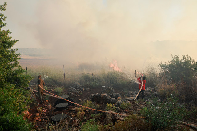  People use hoses to extinguish flames, amid ongoing cross-border hostilities between Hezbollah and Israeli forces, in Dishon, near Kiryat Shmona, northern Israel, June 4, 2024. (credit: REUTERS/AMMAR AWAD)