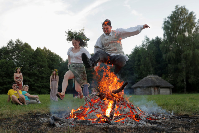  People jump over a campfire as they take part in the Ivan Kupala festival in Belarusian state museum of folk architecture and rural lifestyle near the village Aziarco, Belarus, July 4, 2020. (credit: REUTERS/VASILY FEDOSENKO)