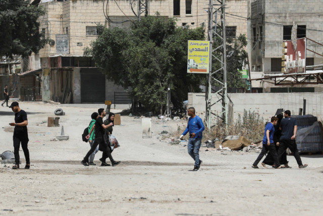  Palestinos caminan, en Yenín, Cisjordania, el 21 de mayo de 2024.  (credit: REUTERS/RANEEN SAWAFTA)