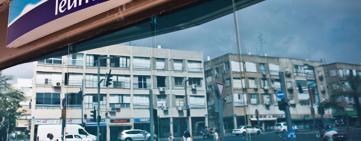 Pedestrians are reflected in the windows of a branch of Bank Leumi, Israel's second-largest lender, in Tel Aviv, Israel