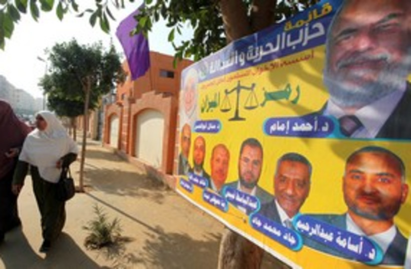 Egyptian women walk past a Muslim Brotherhood poster 311 (R) (photo credit: REUTERS/Amr Abdallah Dalsh)