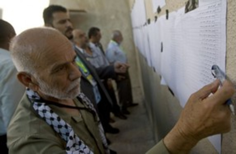 Fatah member looks at list of candidates 311 (R) (photo credit: Fadi Arouri / Reuters)