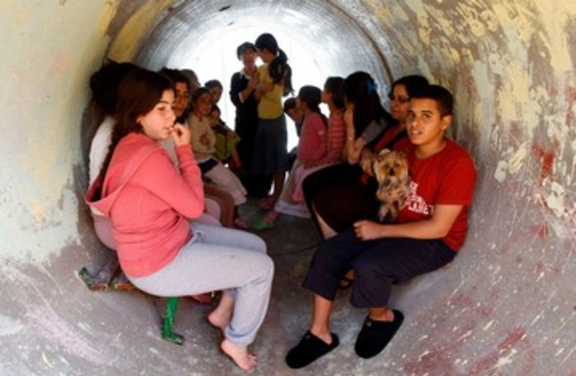 Children take shelter from rockets in a sewage pipe 390 (R) (photo credit: REUTERS/Baz Ratner)