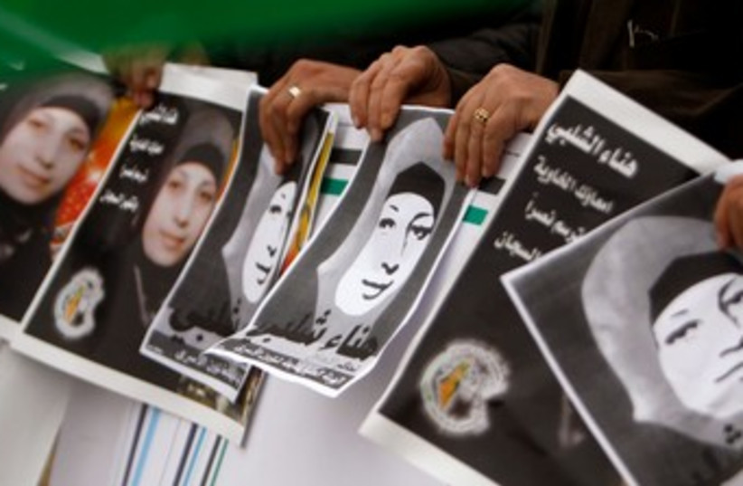 Palestinian protesters hold pictures of Hana Shalabi 370 R  (photo credit: REUTERS)