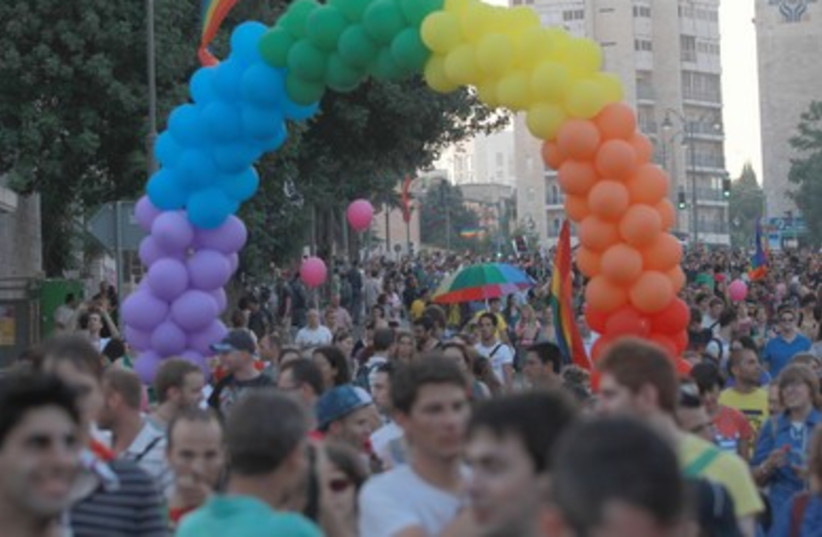 Parade marches beneath arch of rainbow balloons