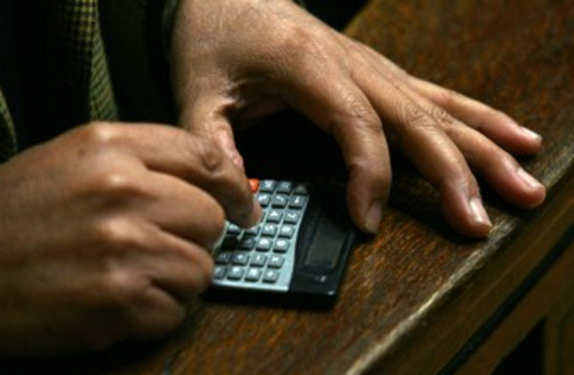 An accountant calculator taxes 370 (credit: Ivan Alvarado / Reuters)