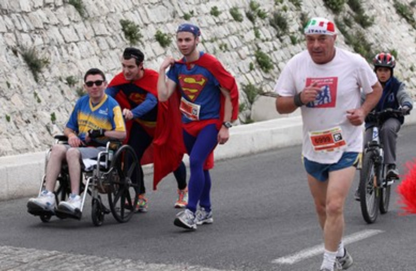 Superman pushes man in weelchair at marathon 390