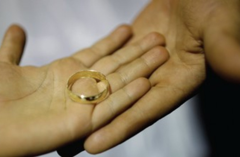 Couple holding a wedding rings 370 (photo credit: REUTERS)