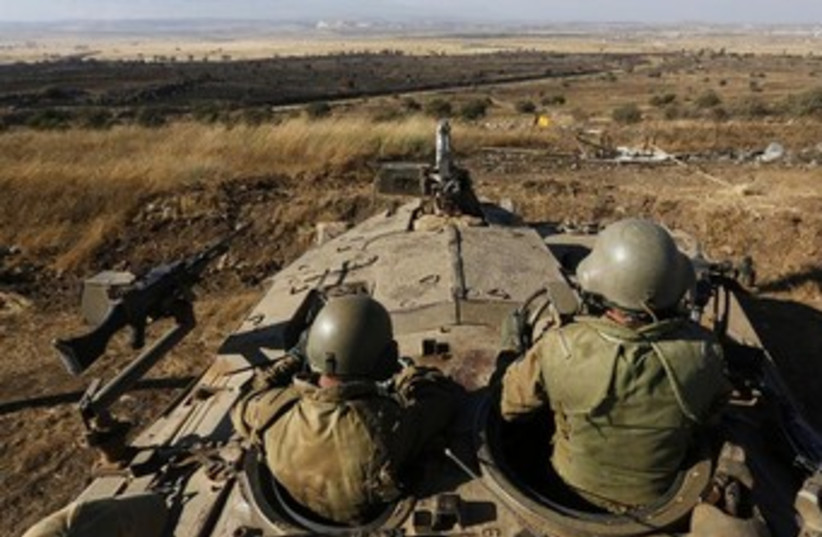 IDF troops survey golan heights 370 (photo credit: REUTERS)