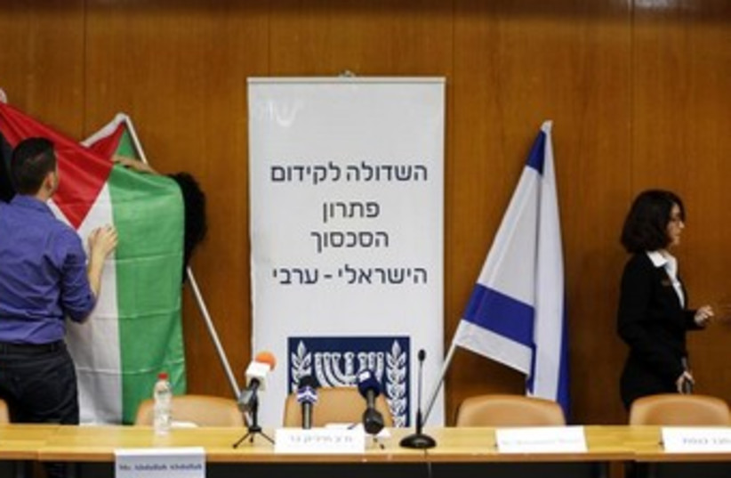 Israeli parliament employees set up a Palestinian flag  (photo credit: Reuters)