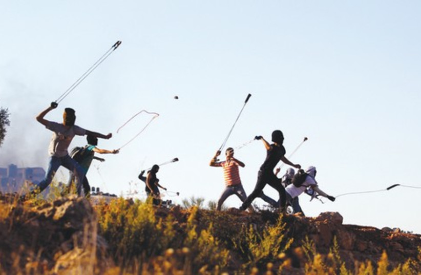 Palestinian youths slinging rocks 521