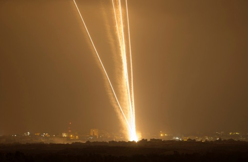 Light streaks and smoke trails are seen as rockets are launched from Gaza towards Israel July 23, 2014 (photo credit: REUTERS)