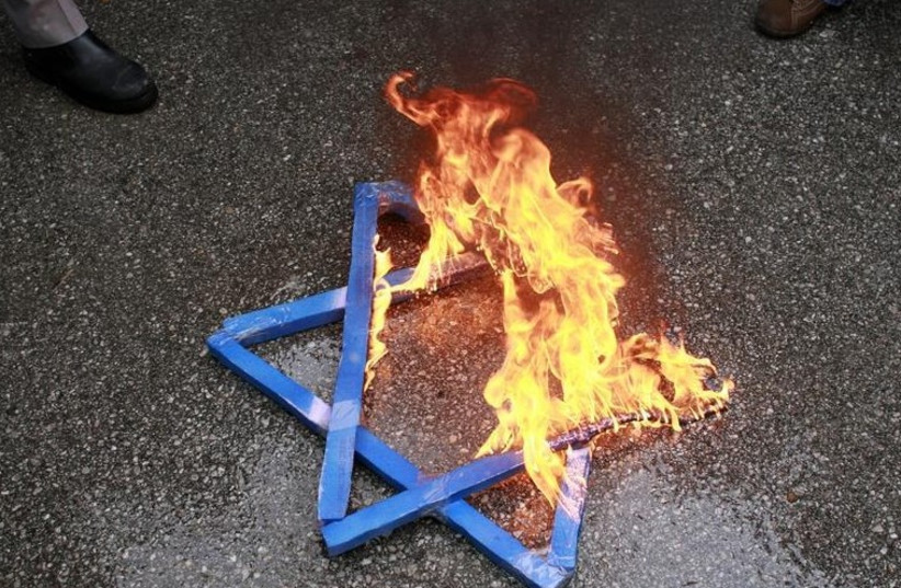 A Star of David burns in flames. (photo credit: REUTERS)