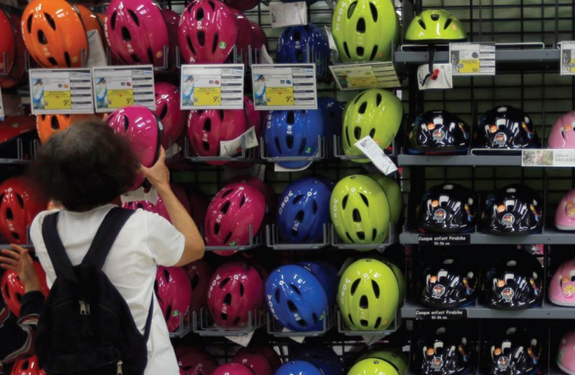 A woman shops for a bicycle helmet (photo credit: REUTERS)
