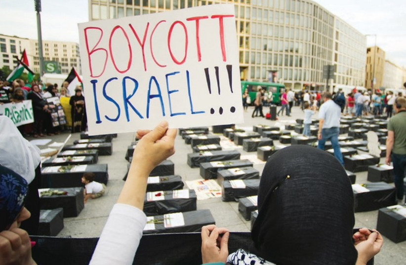 A WOMAN holds a sign during an anti-Israel protest in Berlin on August 1. (photo credit: REUTERS)