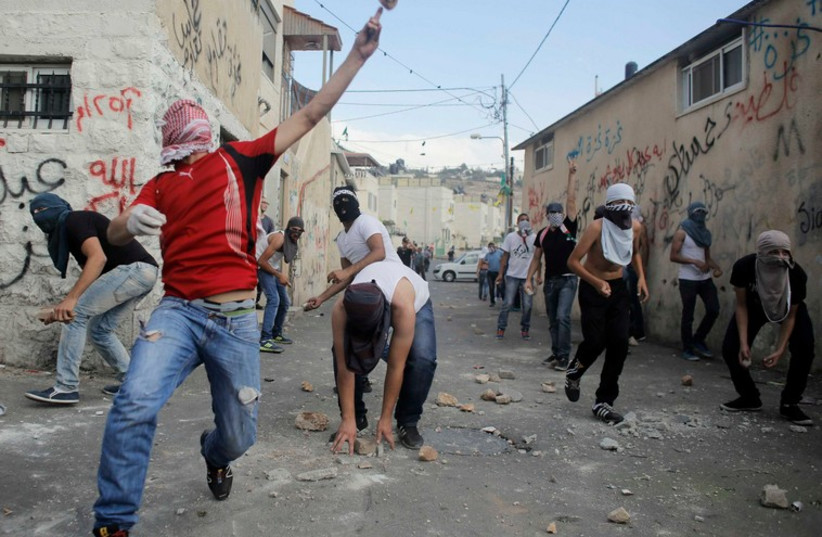 Palestinians hurl stones during clashes with Israeli police in east Jerusalem's Wadi al-Joz neighbourhood [File] (photo credit: REUTERS)