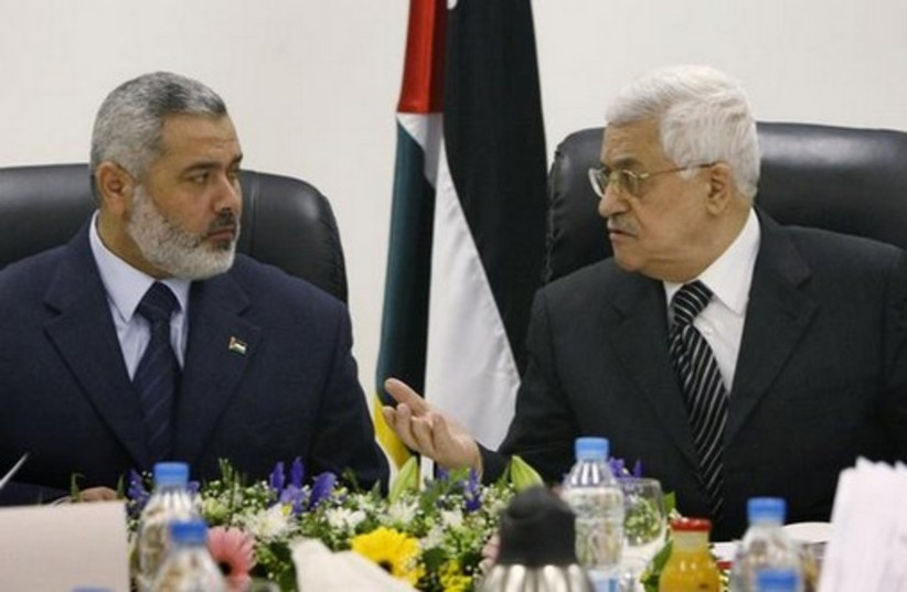 Palestinian Authority President Mahmoud Abbas (R) talks with Hamas leader Ismail Haniyeh. (photo credit: REUTERS)