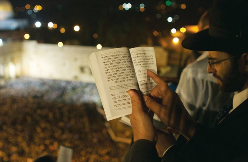 People pray ahead of Yom Kippur on the roof of a seminary overlooking the Western Wall, in Jerusalem’s Old City in 2012. (photo credit: REUTERS)