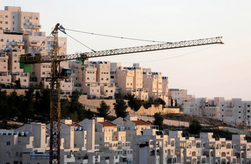 A crane is seen next to Har Homa in Jerusalem (photo credit: REUTERS)