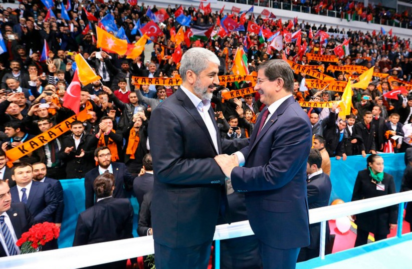 Senior Hamas leader Khaled Mashal shakes hands with Turkish Prime Minister Ahmet Davutoglu during a meeting of Turkey's ruling AK Party (AKP) December 27 (photo credit: REUTERS)