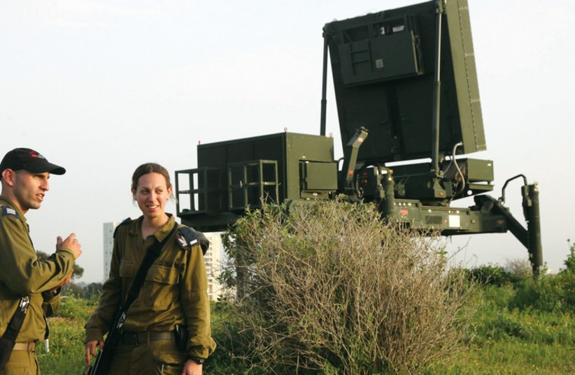 Soldiers stand near the Iron Dome missile defense system outside Tel Aviv. (photo credit: MARC ISRAEL SELLEM/THE JERUSALEM POST)