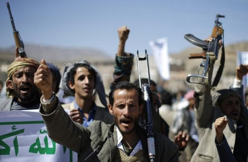 Followers of the Houthi movement shout slogans during a gathering to show support to the movement outside the Presidential Palace in Sanaa (credit: REUTERS)