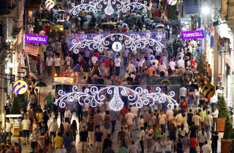People walk along a main shopping street in Istanbul, Turkey (photo credit: REUTERS)