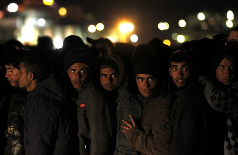 Migrants wait at Italian checkpoint prior to processing  (photo credit: REUTERS)