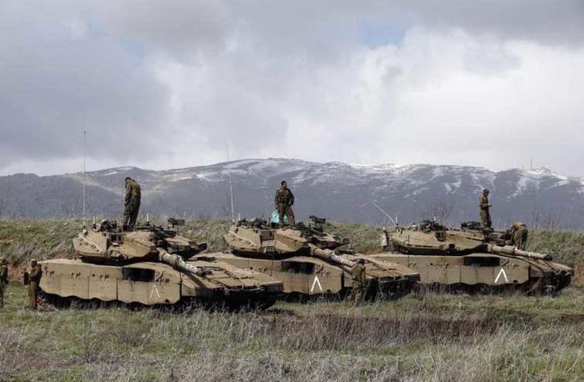 Israeli soldiers stand atop tanks in the Golan Heights near Israel's border with Syria (photo credit: REUTERS)