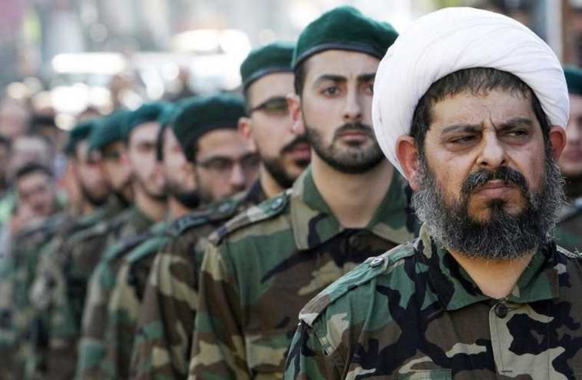A Shi'ite cleric wearing military uniform with Hezbollah members. (photo credit: REUTERS)