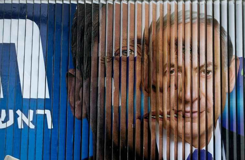 Prime Minister Benjamin Netanyahu and Isaac Herzog, Co-leader of the centre-left Zionist Union, are pictured together as campaign billboards rotate in Tel Aviv (photo credit: REUTERS)