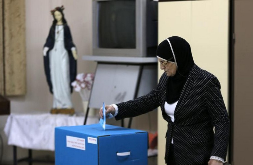 An Israeli Arab casts her ballot at a polling station inside a church in the northern town of Reineh (photo credit: REUTERS)