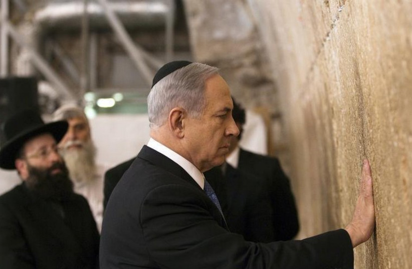 Prime Minister Benjamin Netanyahu touches the stones of the Western Wall (photo credit: REUTERS)